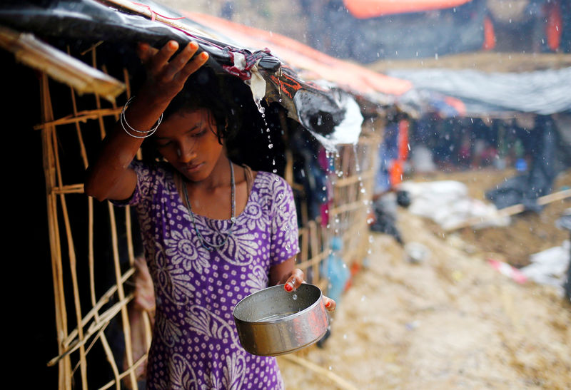 © Reuters. A Rohingya refugee girl collects rain water at a makeshift camp in Cox's Bazar