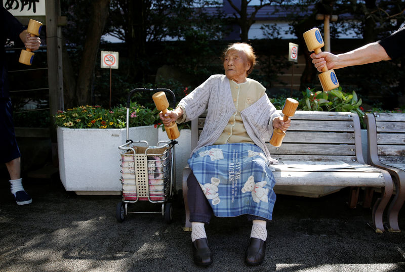 © Reuters. Natsu Naruse, 100 year-old, exercises with wooden dumbbells during a health promotion event to mark Japan's "Respect for the Aged Day" at a temple in Tokyo's Sugamo district