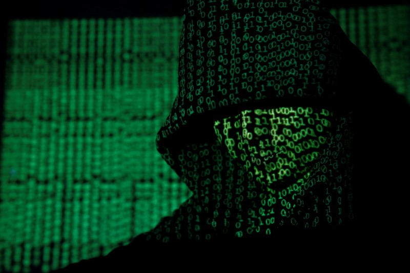 © Reuters. Projection of cyber code on hooded man is pictured in this illustration picture