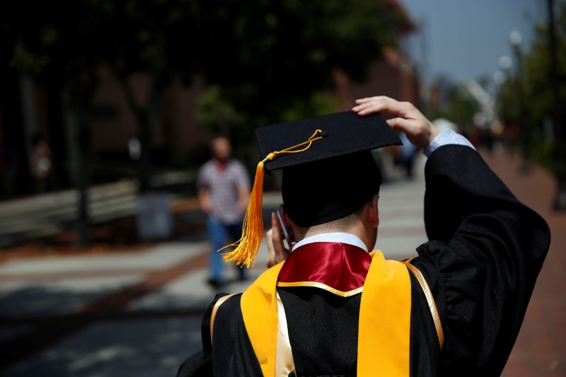 © Reuters. A graduate holds their mortarboard cap after a commencement ceremony at the University of Southern California (USC) in Los Angeles, California