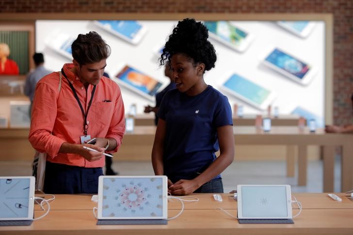 © Reuters. Funcionário mostra tablets para cliente em loja da Apple em Nova York, Estados Unidos