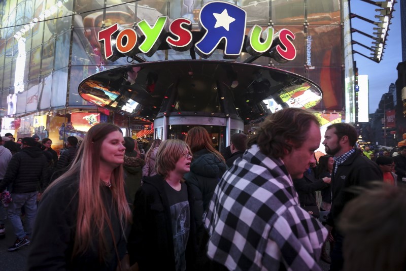 © Reuters. FILE PHOTO - People walk past Toys R Us in Times Square the day after Christmas in the Manhattan borough of New York