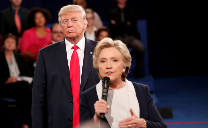 © Reuters. FILE PHOTO: Republican U.S. presidential nominee Trump listens as Democratic nominee Clinton answers a question from the audience during their presidential town hall debate in Washington