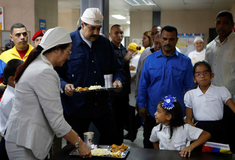 © Reuters. Venezuela's President Nicolas Maduro serves lunch during an event related to the beginning of classes at a school in Caracas