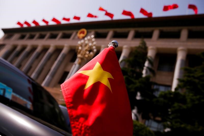 © Reuters. FILE PHOTO: The Vietnamese national flag flies on a diplomatic car outside the Great Hall of the People before talks between Vietnam's President Tran Dai Quang and Chinese leaders in Beijing