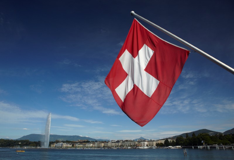© Reuters. FILE PHOTO: Swiss flag is pictured next to Jet d'Eau and Lake Leman from the St-Pierre Cathedrale in Geneva