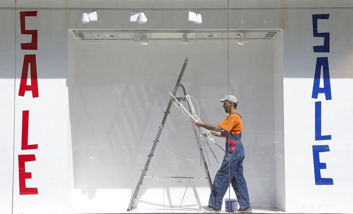 © Reuters. A worker is seen behind a front window as he takes part in the construction of a shop in central Moscow