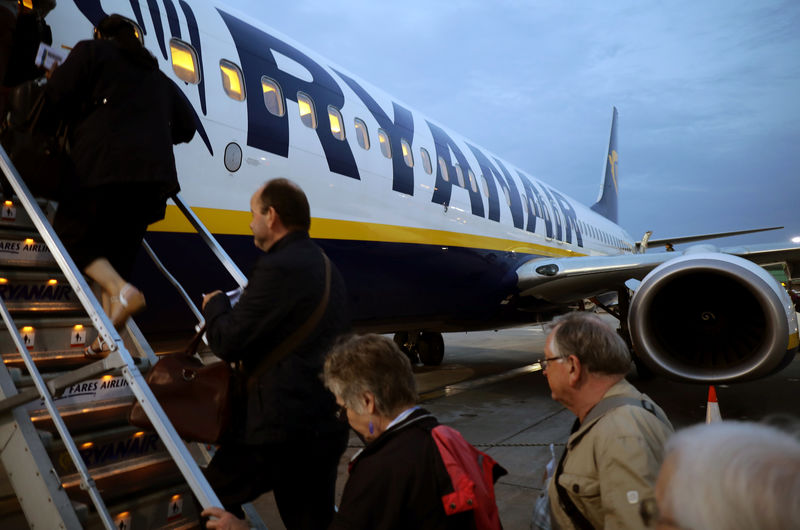 © Reuters. FILE PHOTO - People board a Ryanair flight at Stansted Airport, northeast of London, Britain