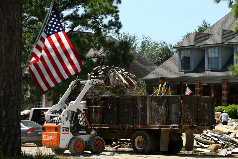 © Reuters. Workers begin the task of carting away the flood damaged contents and interiors of homes following the aftermath of tropical storm Harvey in Katy, Texas