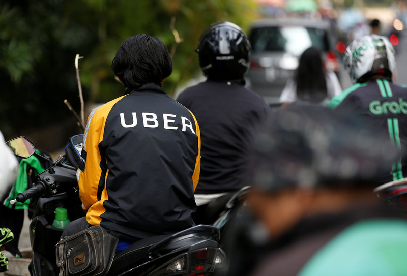 © Reuters. An Uber motorcycle taxi driver waits for customers next to a shopping mall in Jakarta