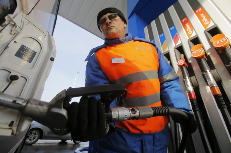 © Reuters. Pump attendant fills the tank of a vehicle at Gazpromneft petrol station in Moscow