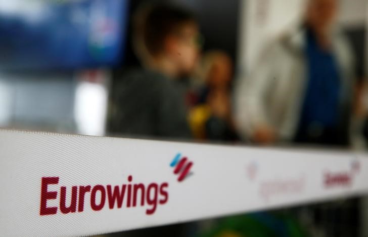 © Reuters. People line up behind a barrier tape of Lufthansa's budget airlines Eurowings during a 24-hour strike over pay and working conditions at Cologne-Bonn airport