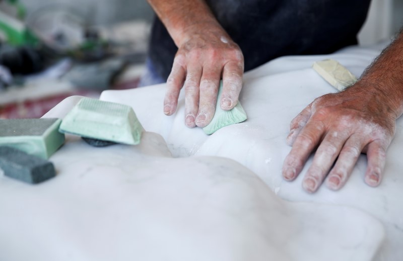 © Reuters. A worker cleans a marble sculpture at the Henraux factory in Querceta, Tuscany