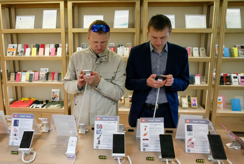 © Reuters. FILE PHOTO: Men try out Xiaomi smartphones at the company's store in central Kiev, Ukraine