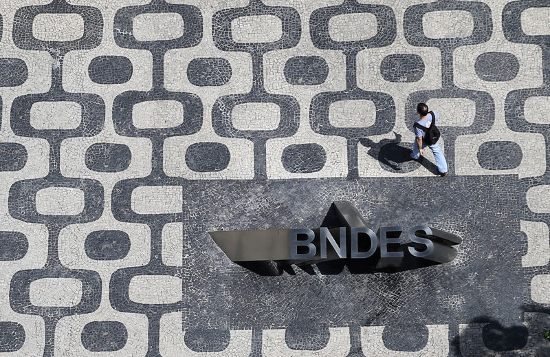 © Reuters. Homem passa por logo do Banco Nacional de Desenvolvimento Econômico e Social (BNDES) na sede do banco no Rio de Janeiro