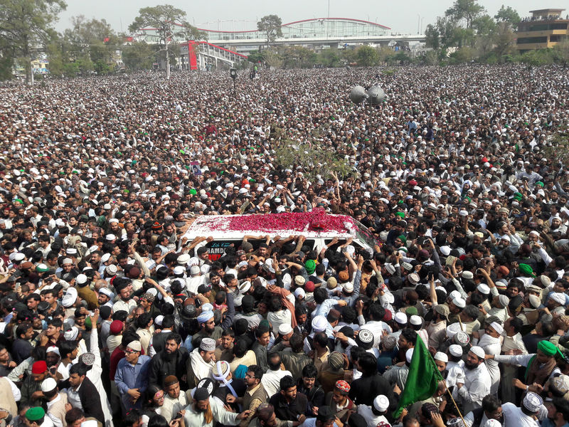 © Reuters. FILE PHOTO Mourners throw flower petals on an ambulance carrying the body of Mumtaz Qadri to his funeral which Pakistani broadcast media were forbidden to cover at Liaquat Bagh in Rawalpindi