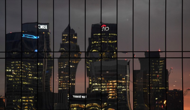 © Reuters. The Canary Wharf business district is seen reflected in windows at dusk in London