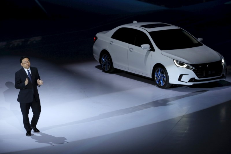 © Reuters. BYD Co Ltd Chairman and President Wang Chuanfu speaks next to its hybrid electric car 'Qin' at BYD Dreamcast conference in Beijing