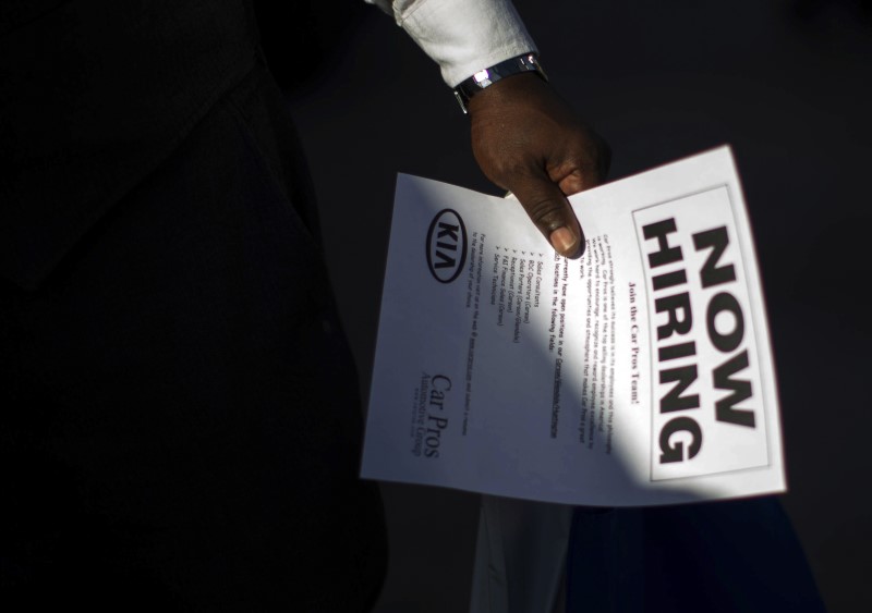 © Reuters. Man holds a leaflet at a military veterans' job fair in Carson