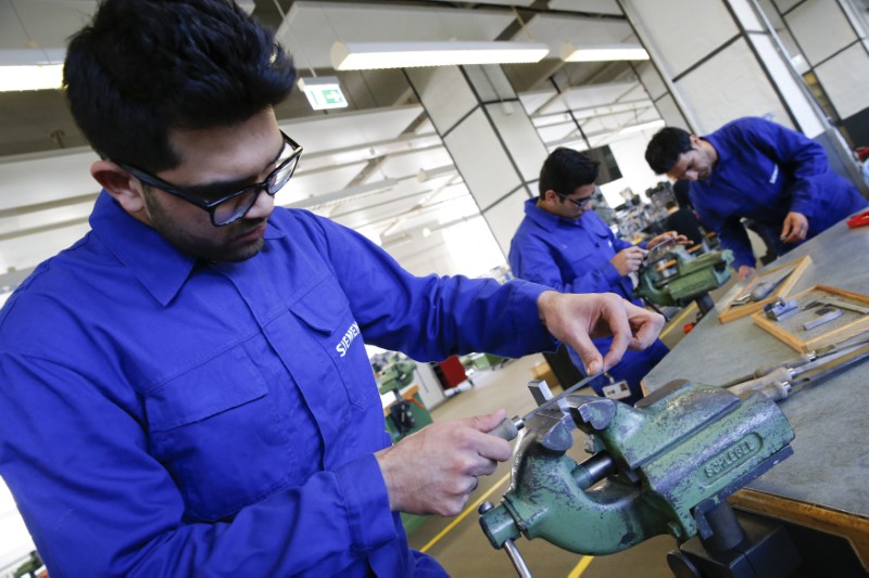 © Reuters. Refugees show their skills in metal processing works during a media tour at a workshop for refugees organized by German industrial group Siemens in Berlin