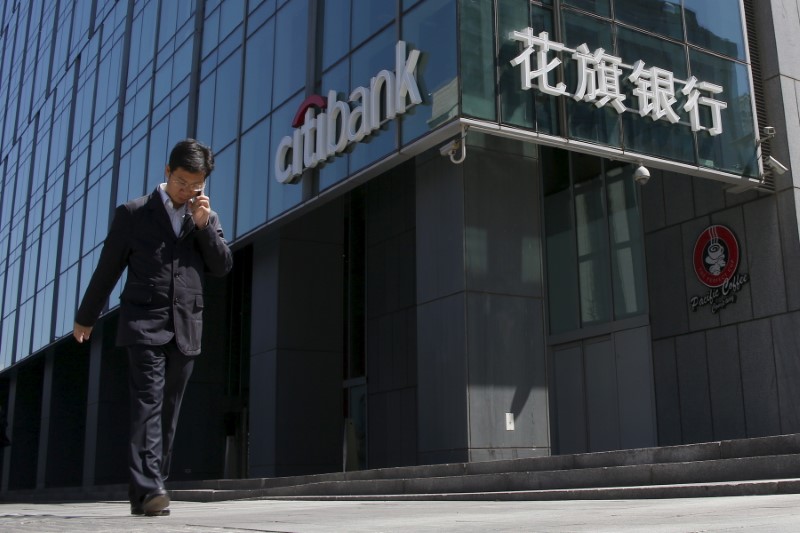 © Reuters. A man walks past a branch of Citibank in Beijing