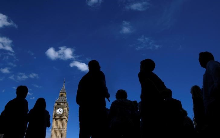 © Reuters. Tourists view the Elizabeth Tower, which houses the Great Clock and the 'Big Ben' bell, at the Houses of Parliament, in central London
