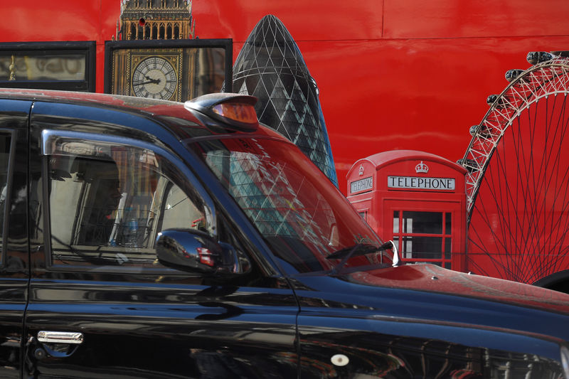 © Reuters. A London cab passes a hoarding with images of some of the city's landmarks, in central London