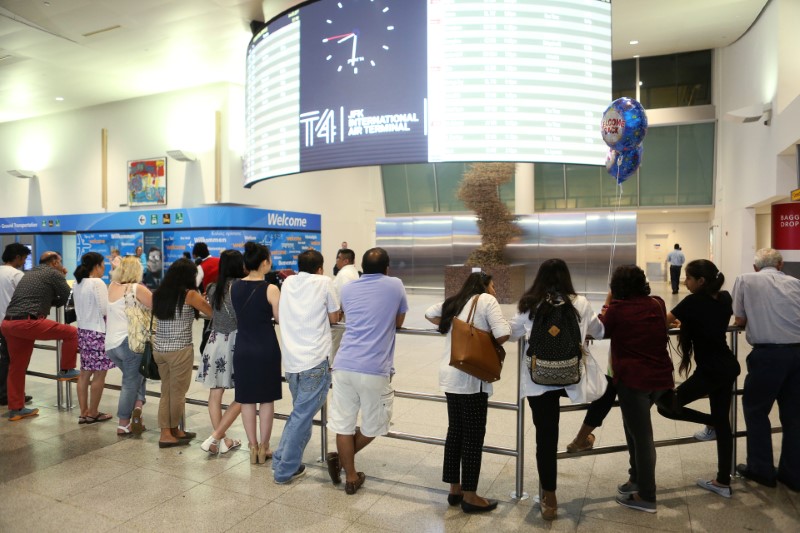 © Reuters. People wait at the arrival hall at Terminal 4 of JFK airport after U.S. President Donald Trump's limited travel ban was approved by the U.S. Supreme Court, in New York City