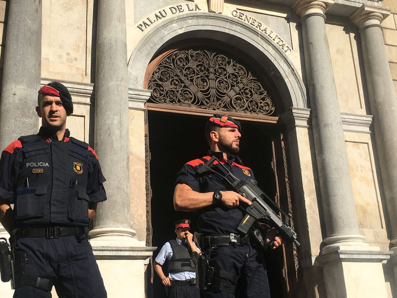 © Reuters. Офицеры региональной полиции охраняют здание правительства Каталонии в Барселоне