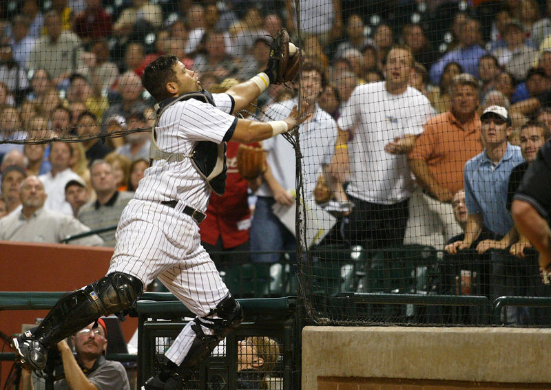 © Reuters. FILE PHOTO: Houston Astros catcher Raul Chavez goes into the netting to catch a foul ball off the bat of Pittsburgh Pirates Jack Wilson
