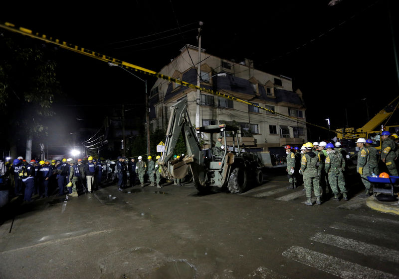 © Reuters. A soldier drives an excavator on a street as rescue teams search for students at the Enrique Rebsamen school after an earthquake in Mexico City