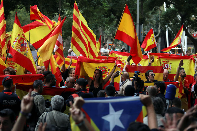 © Reuters. Protesters against a banned referendum on independence in Catalonia hold Spanish flags as a pro-independence demonstrator (front) displays an Estelada (Catalan separatist flag) during a demonstration in Barcelona