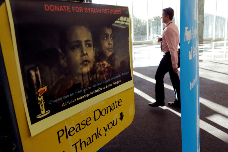 © Reuters. A man walks near a box for donations to Syrian refugees during the 72nd United Nations General Assembly at U.N. headquarters in New York