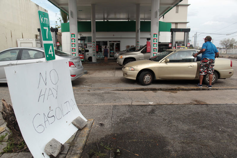 © Reuters. People arrive to buy gasoline next to a sign reading "There is no gasoline," at a gas station, after the area was hit by Hurricane Maria, in San Juan
