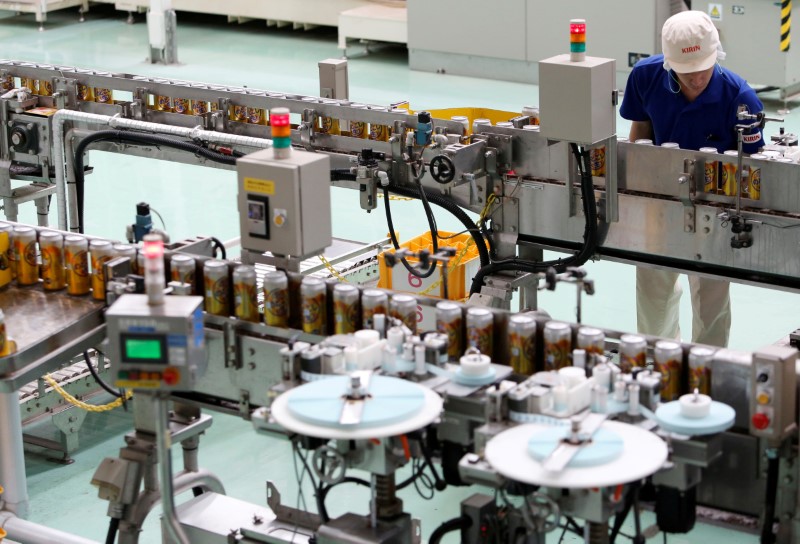 © Reuters. FILE PHOTO - Employee works at a beer production line at Japanese brewer Kirin Holdings' factory in Toride