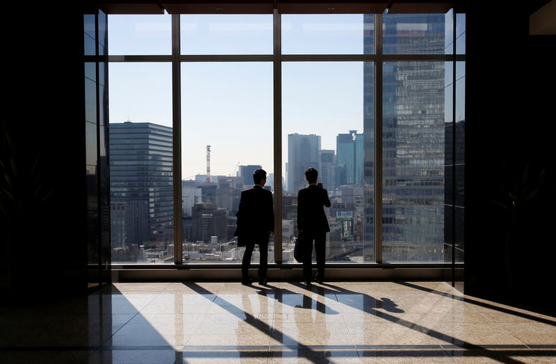 © Reuters. FILE PHOTO - Businessmen are seen inside a high-rise office building in Tokyo