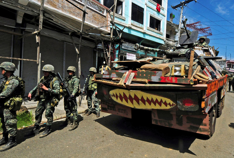 © Reuters. FILE PHOTO: An Armoured Personnel Carrier (APC) and government troops march towards Mapandi bridge after 100 days of intense fighting between soldiers and insurgents from the Maute group, who have taken over parts of Marawi city