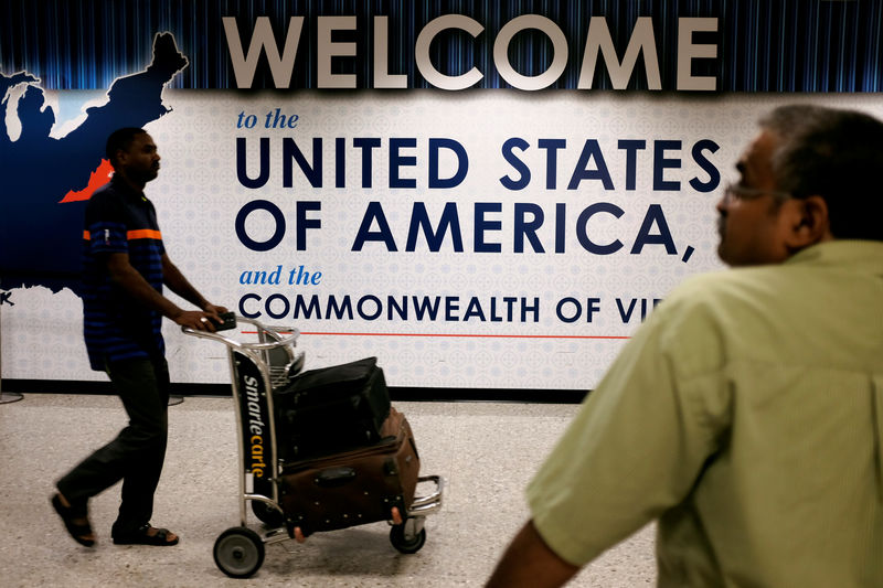 © Reuters. An international passenger arrives at Dulles International Airport as a man waits for loved ones to arrive in Dulles, Virginia