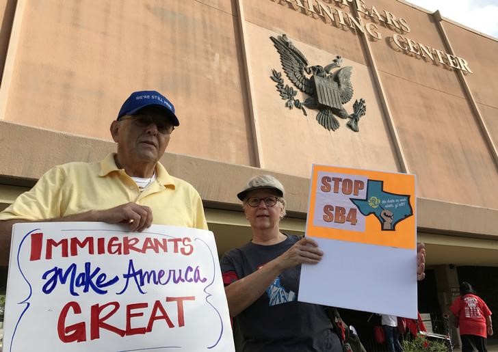 © Reuters. Prtotesters against the Texas state law to punish "sanctuary cities" stands outside the U.S. Federal court in San Antonio