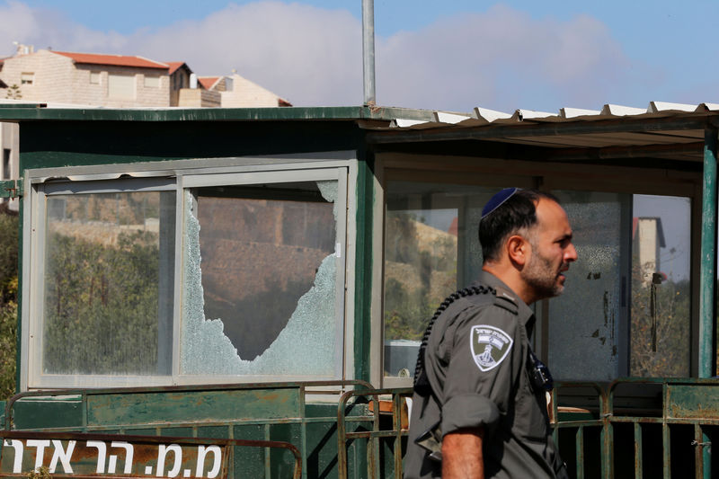 © Reuters. Policial israelense passa por posto de controle danificado depois que palestino deixou três guardas israelenses mortos em assentamento judeu, na Cisjordânia ocupada