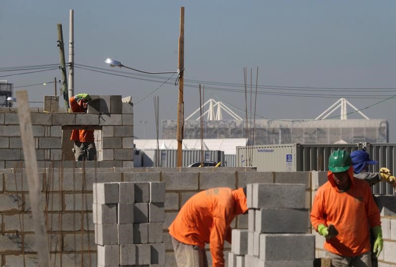 © Reuters. Homens trabalham na construção de casas para 20 famílias no Rio de Janeiro, Brasil