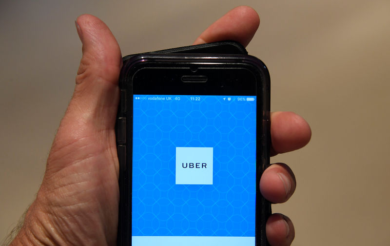 © Reuters. A photo illustration shows the Uber app logo displayed on a mobile telephone, as it is held up for a posed photograph in central London