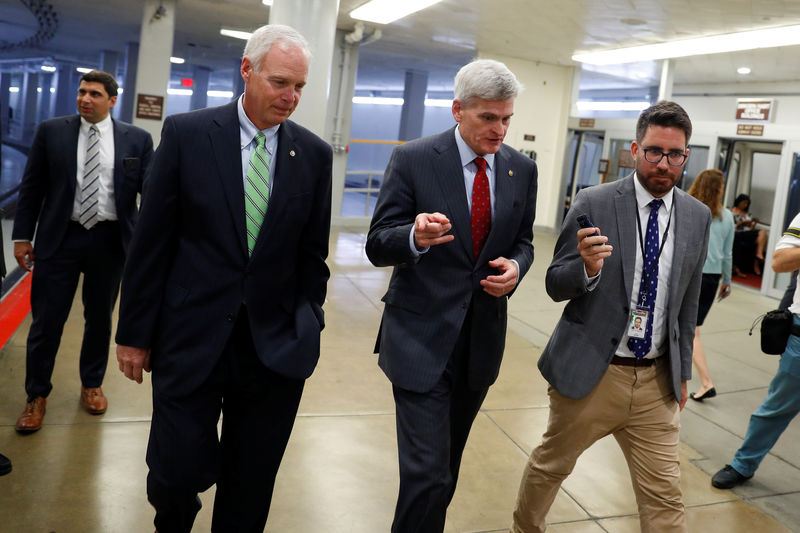 © Reuters. Sen. Bill Cassidy (R-LA), accompanied by Sen. Ron Johnson (R-WI) at left, speaks with reporters ahead of the party luncheons on Capitol Hill in Washington