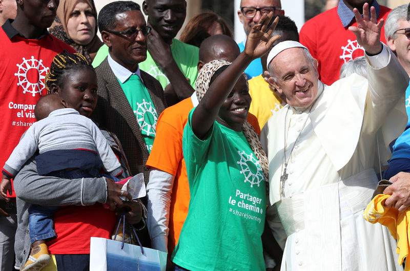 © Reuters. Papa Francisco posa com imigrantes na Praça São Pedro