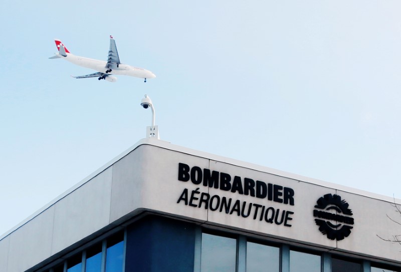 © Reuters. FILE PHOTO - A plane flies over a Bombardier plant in Montreal