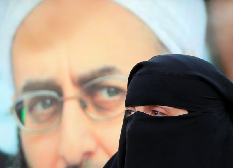 © Reuters. A supporter of detained Lebanese hardline Sunni Islamist cleric Ahmad al-Assir stands in front of his picture during a protest after a Lebanese military court sentenced him to death by execution, in Sidon