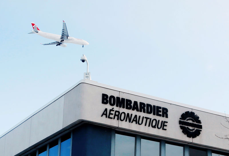 © Reuters. FILE PHOTO - A plane flies over a Bombardier plant in Montreal