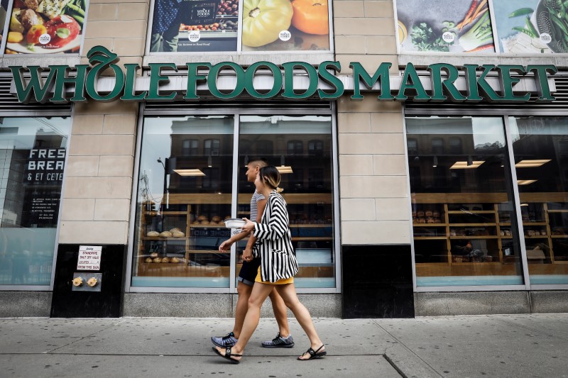 © Reuters. People pass by a Whole Foods store in New York