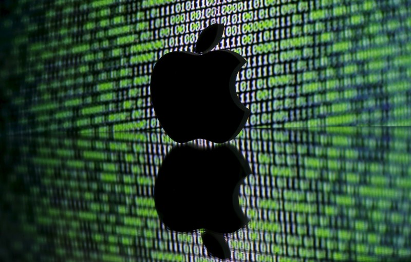 © Reuters. A 3D printed Apple logo is seen in front of a displayed cyber code in this illustration