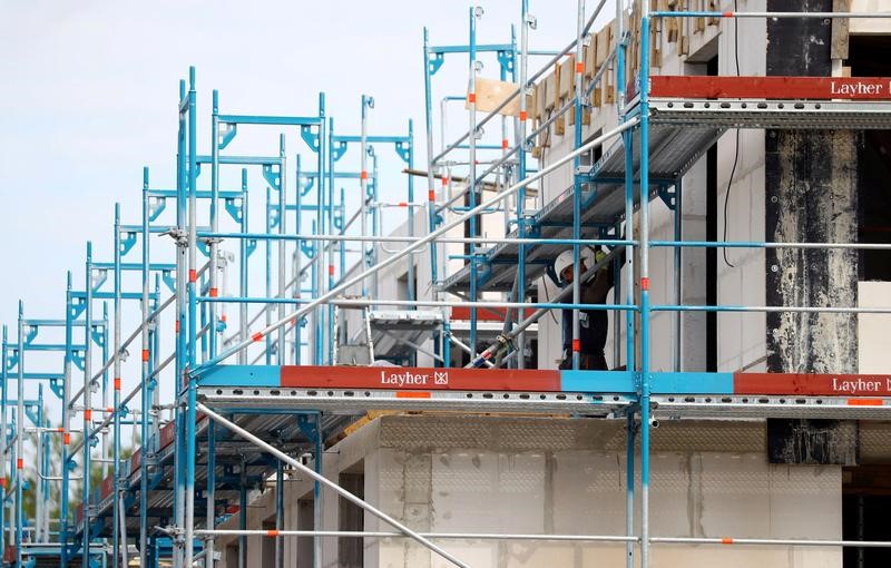 © Reuters. FILE PHOTO: A construction worker adjusts a scaffolding on a construction site for family homes in Hanau near Frankfurt